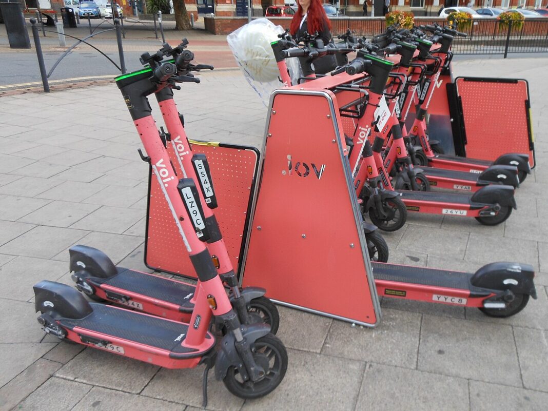 Patinetes elétricos em estacionamento com estrutura para recarga