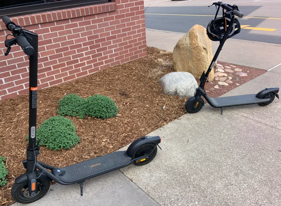 Dois patinetes elétricos compactos estacionados em área urbana
